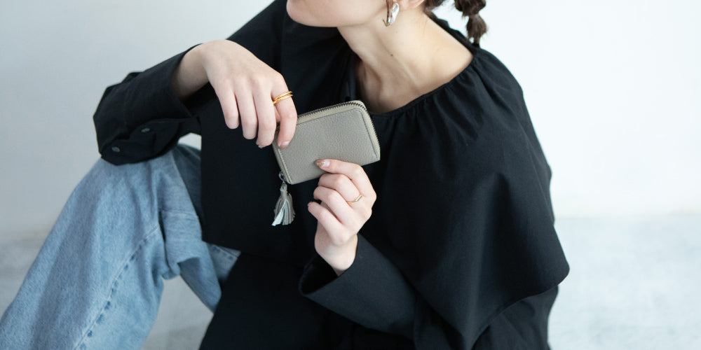 MARLEコインケースを持っている女性